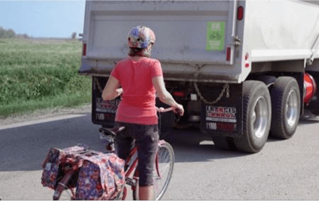 cyclist behind a dump truck
