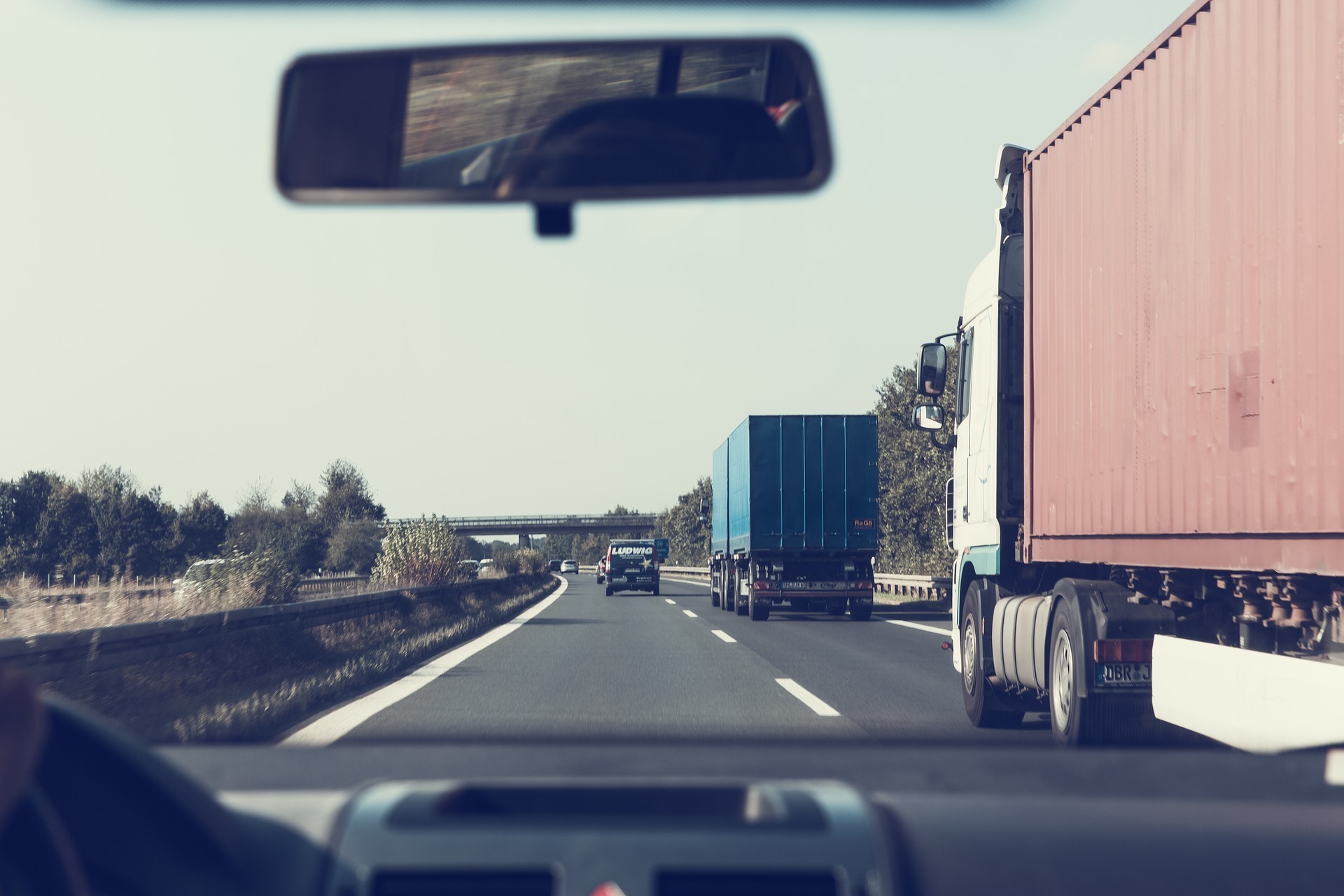 driver looking out front window towards two trucks