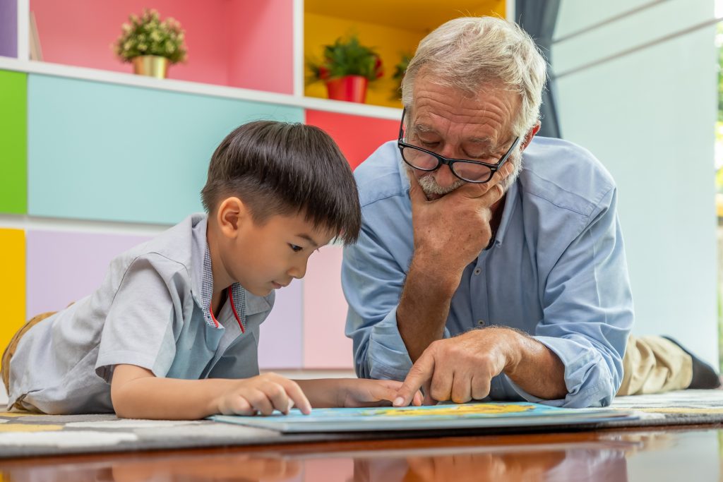 An older adult reading to a boy