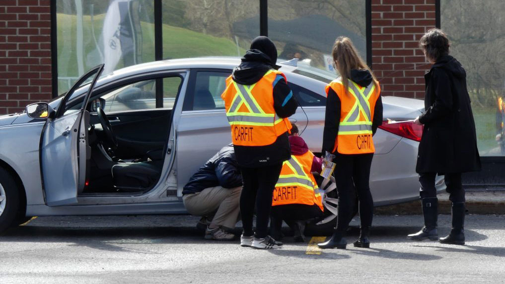 Quelques bénévoles des cliniques CarFit aidant une personne âgée avec la voiture