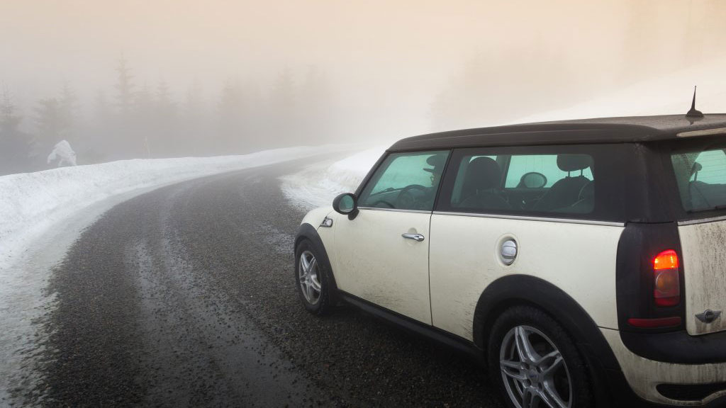 A car going slowly on a slippery and icy road